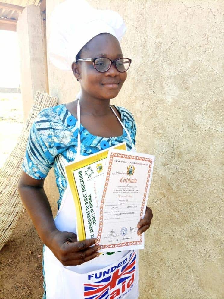 Regina Waye poses for a photo while holding some achievement certificates from school