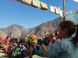 A young girl sings a song as part of an awareness event in Nepal.