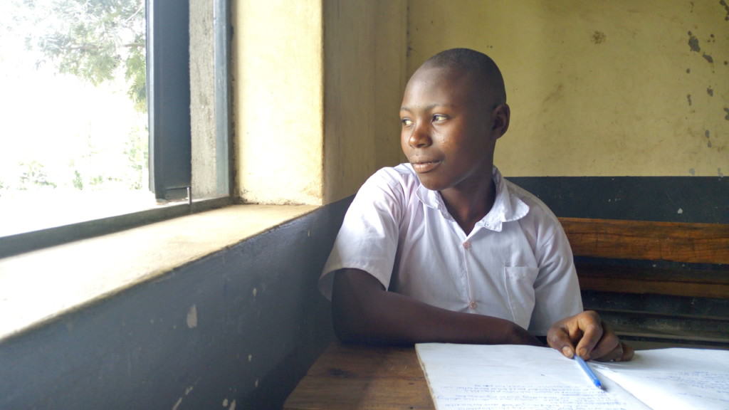 Western Uganda Bantwana Program girl sits and looks out the window