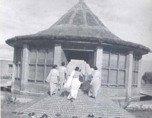Old black and white photo of young women walking into a school building in India. Shows Literacy House, the organization that expanded to become World Education