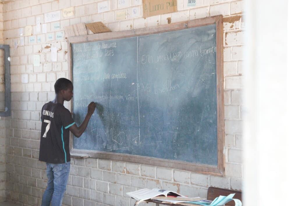 Student in Mozambique writing on chalkboard