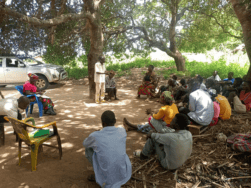 Community gathers in Mozambique in a circle outside