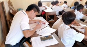 A teacher mentor in Cambodia observes a classroom and takes notes