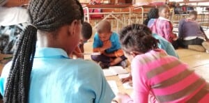 A group of students in different grades gather for targeted instruction sessions in Mozambique